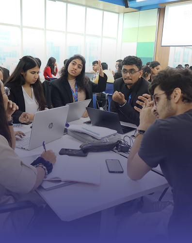 students collaborating in classroom group discussion with laptops and study materials