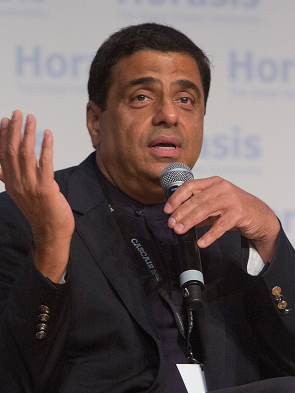 business leader speaking at conference with microphone on stage