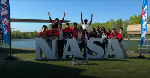 students celebrating at NASA site with rover team achievement and group photo