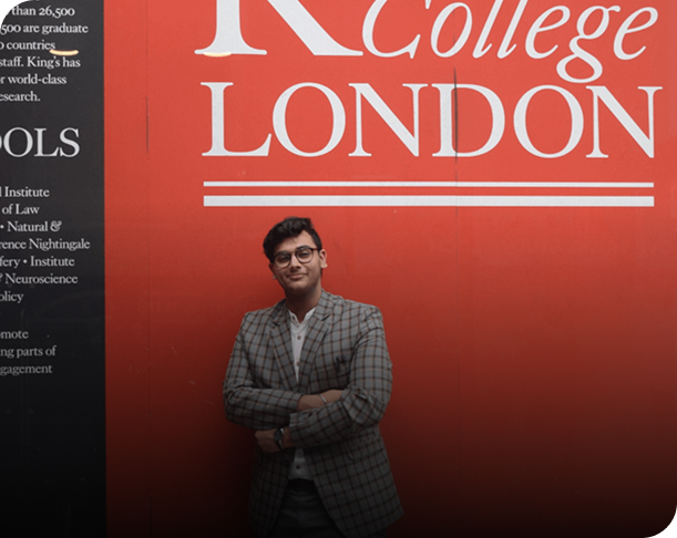 student posing at Kings College London campus wall
