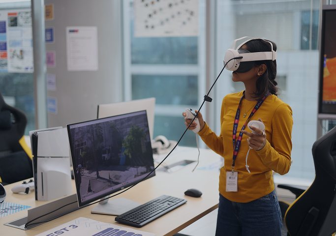 Student testing an immersive virtual reality experience in a technology lab